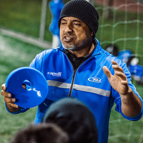 coach helping players at practice