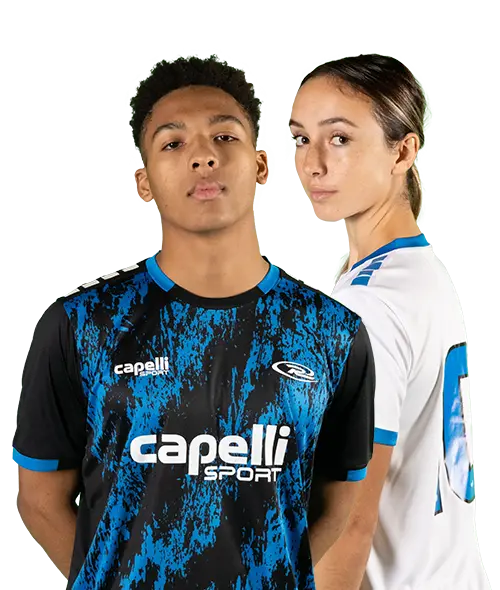 Two people wearing Capelli Sport jerseys: one in a black and blue jersey, standing in front, and another in a white and blue jersey, standing slightly behind. Both are looking at the camera, embodying the spirit of youth soccer with their confident stances.