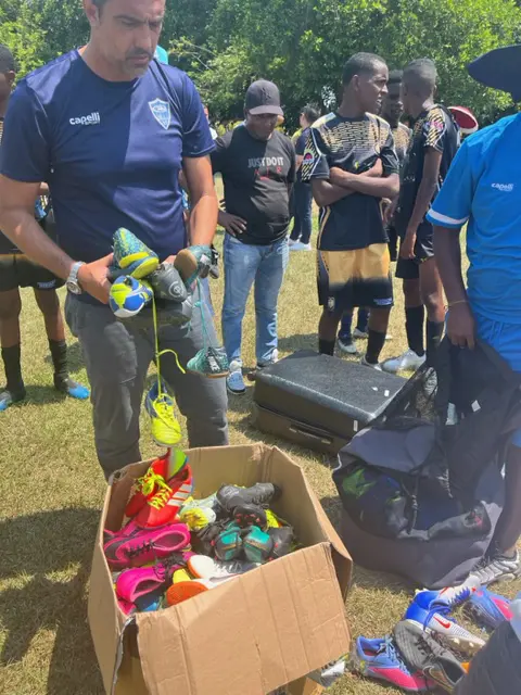 Tiago distributing donated cleats to soccer players in Colombia